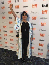 a woman in a kimono is standing on the red carpet at the toronto international film festival
